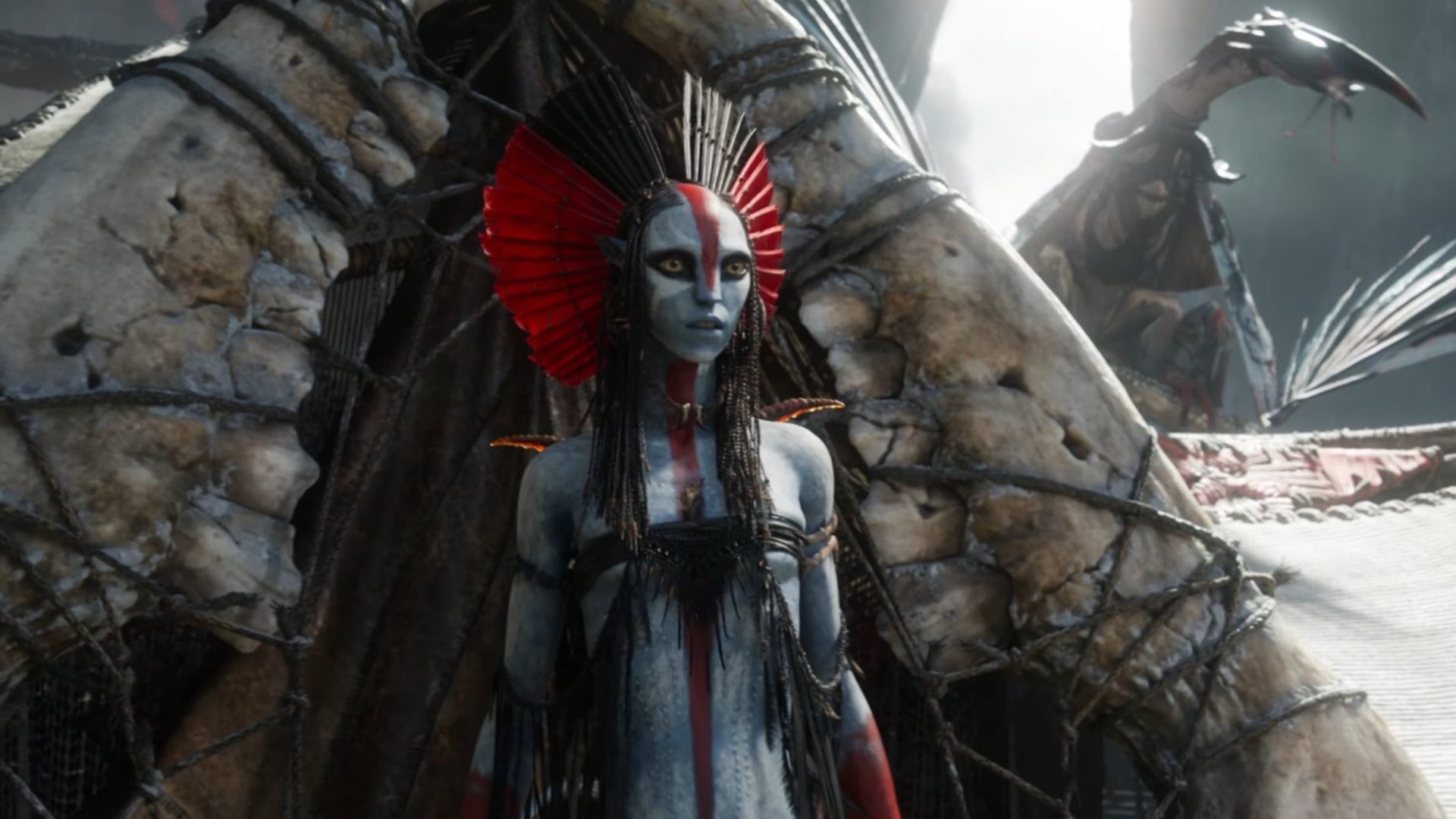 A Na'vi' in red paint stares.