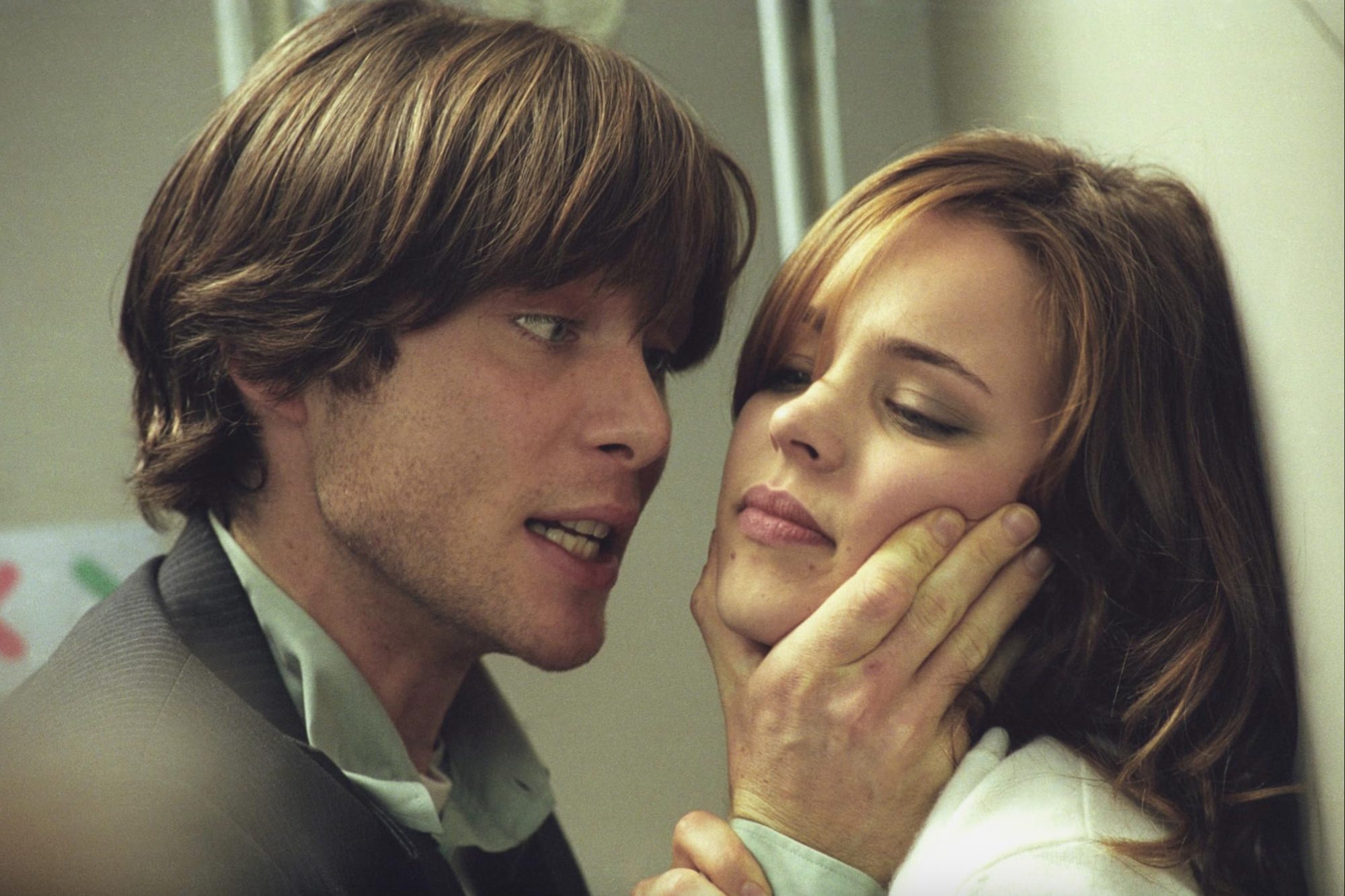 Cillian Murphy touches a woman's face.