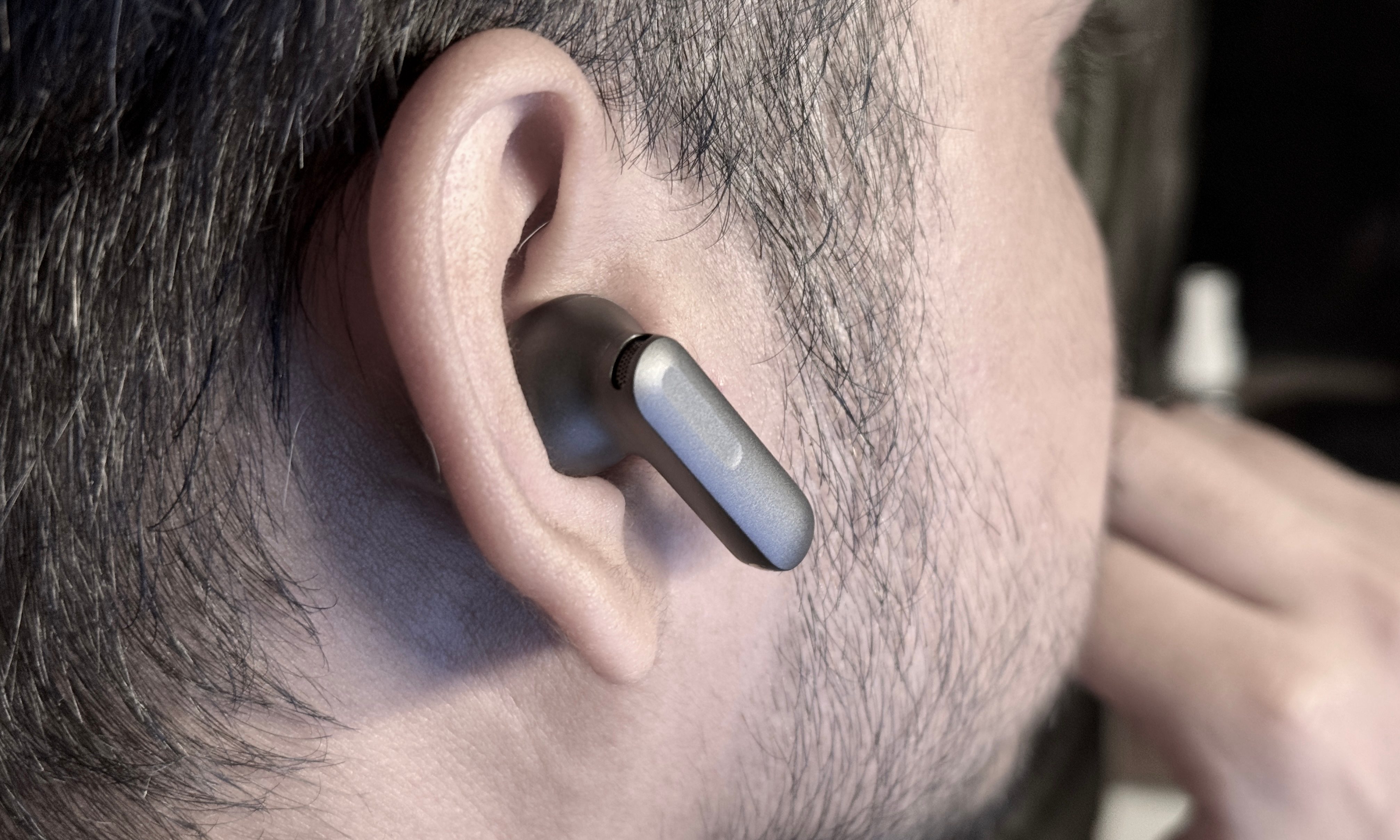 Person wearing the OnePlus Buds 4 earbuds.