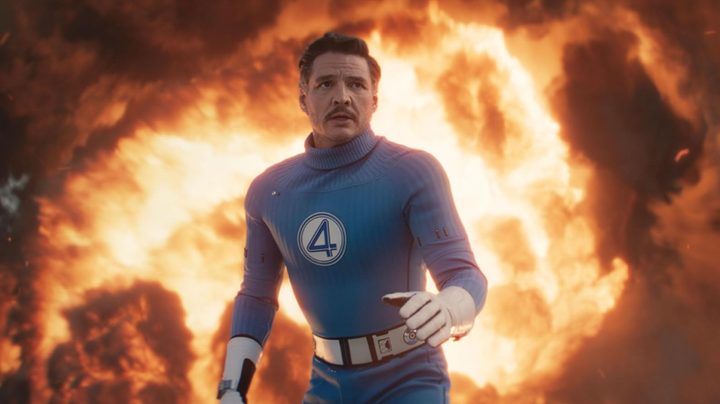 Pedro Pascal stands in front of a fire as Mister Fantastic in the Marvel superhero film, The Fantastic Four: First Steps.