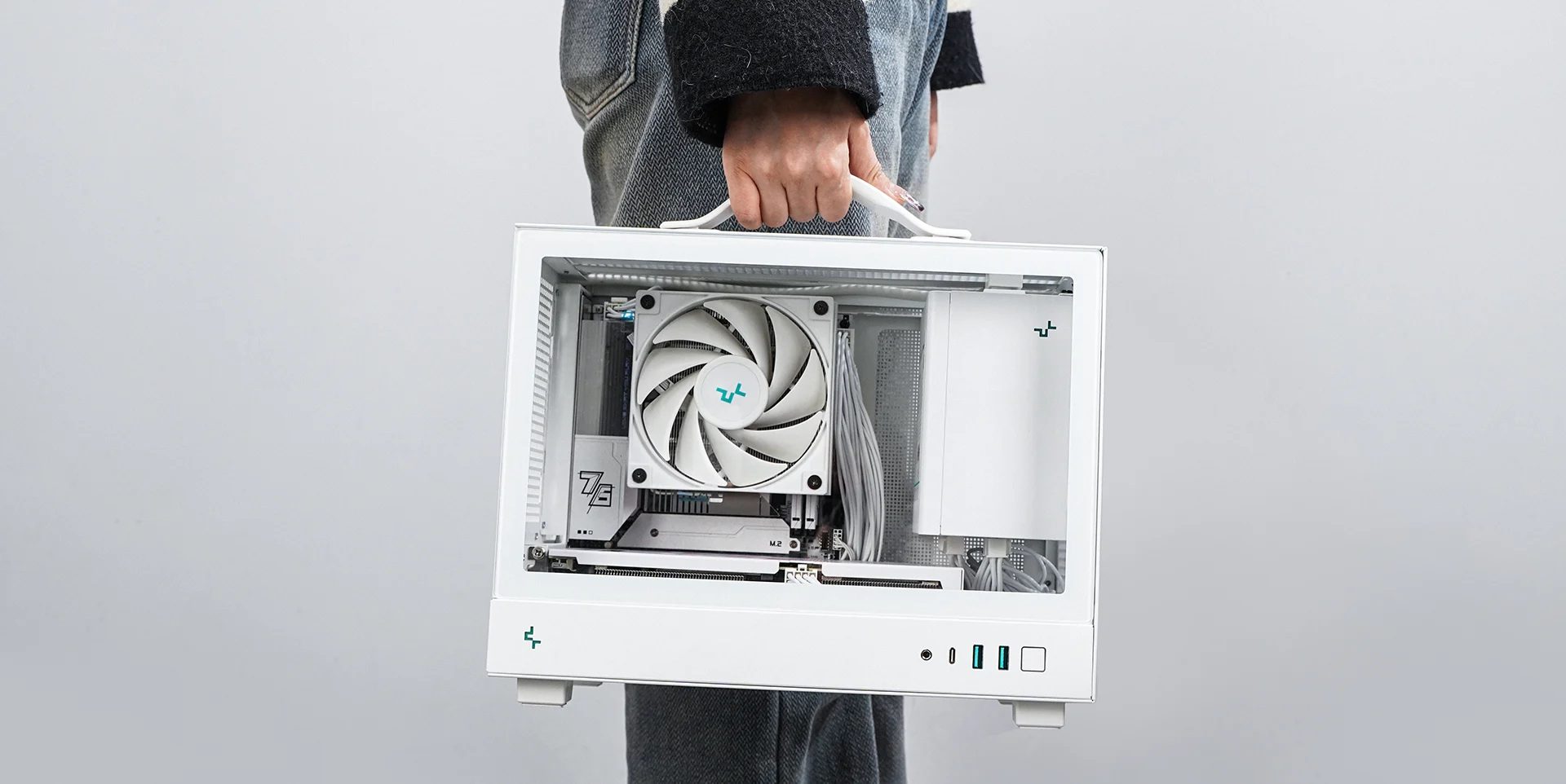 A PC built inside the Deepcool CH160 mini-ITX case is being carried using the included handle