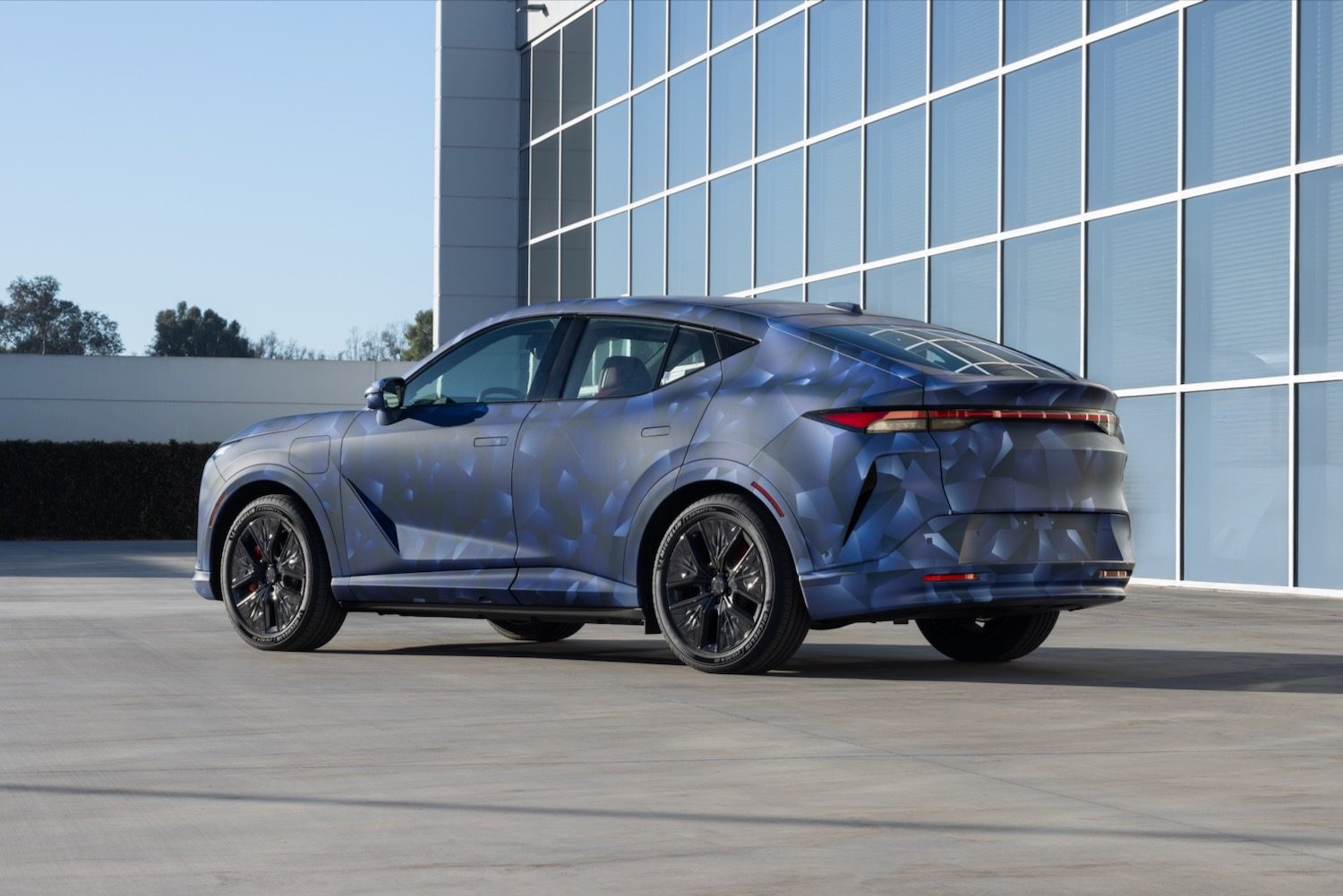 Rear three quarter view of a camouflaged Acura RSX electric SUV.