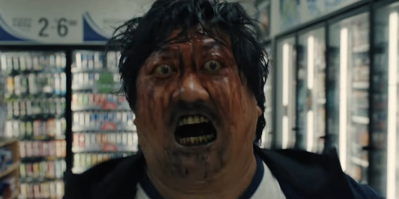 Benedict Wong with a bloodied face and bulging eyes in the horror movie Weapons.