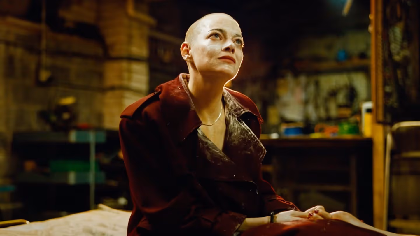 Emma Stone sits down and looks up.