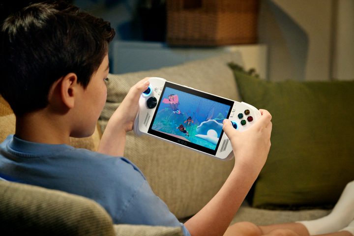 A kid playing the ROG Xbox Ally X on a couch.
