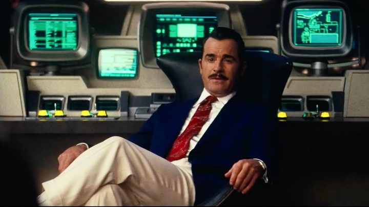 A man in a suit sits down.