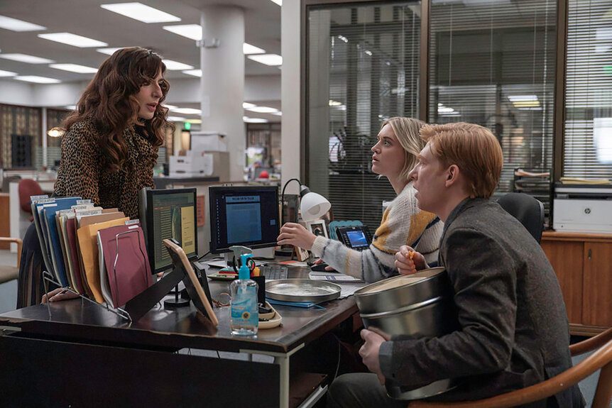 Editor talking to two writers
