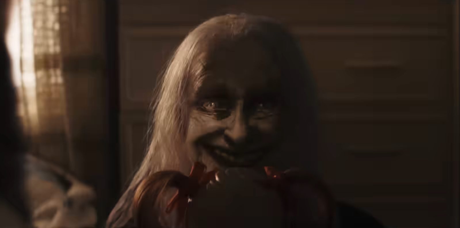 A scary woman smiling in The Conjuring Last Rites.