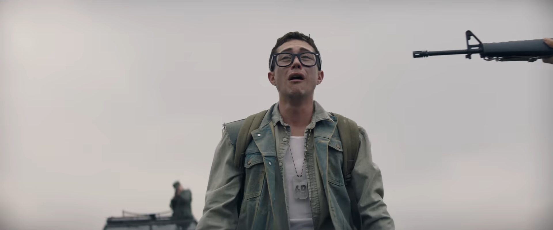 A young man in glasses crying with a gun to his head in The Long Walk.