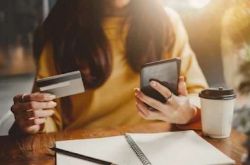 woman holding credit card and phone