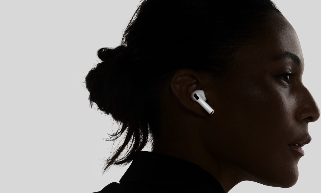 A white AirPods Pro 3 in the ear of a woman
