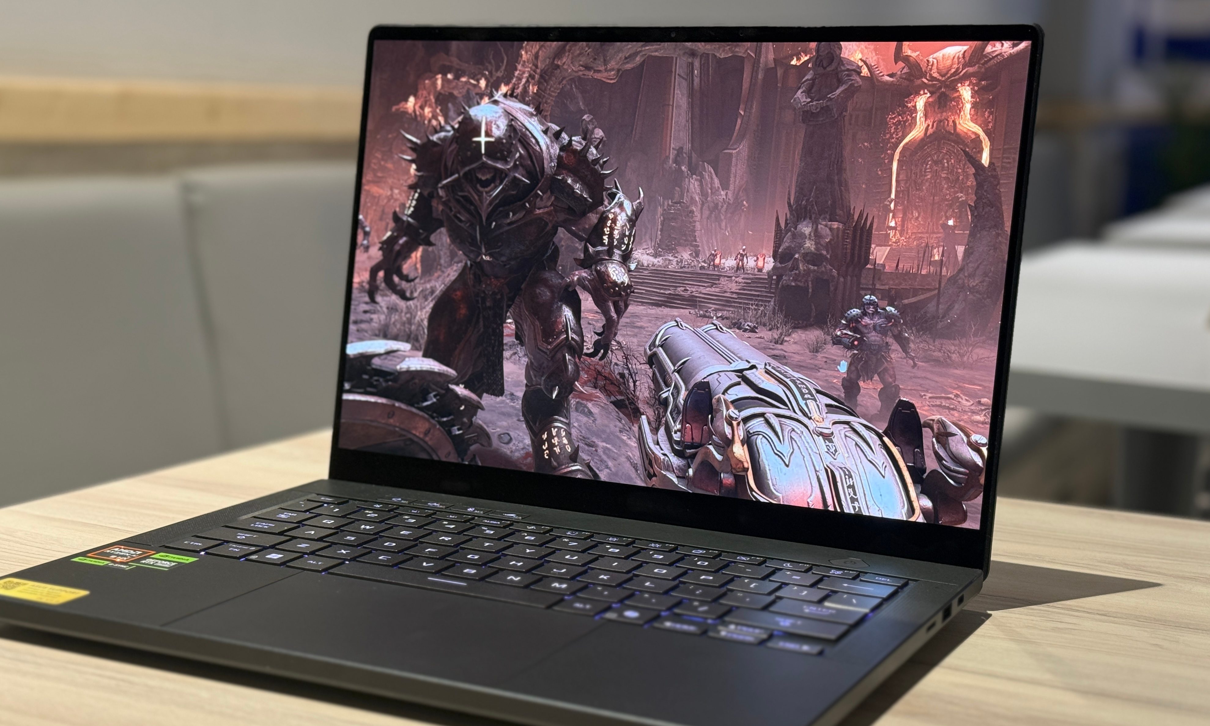 An Asus ROG Zephyrus G14 laptop lies on the table