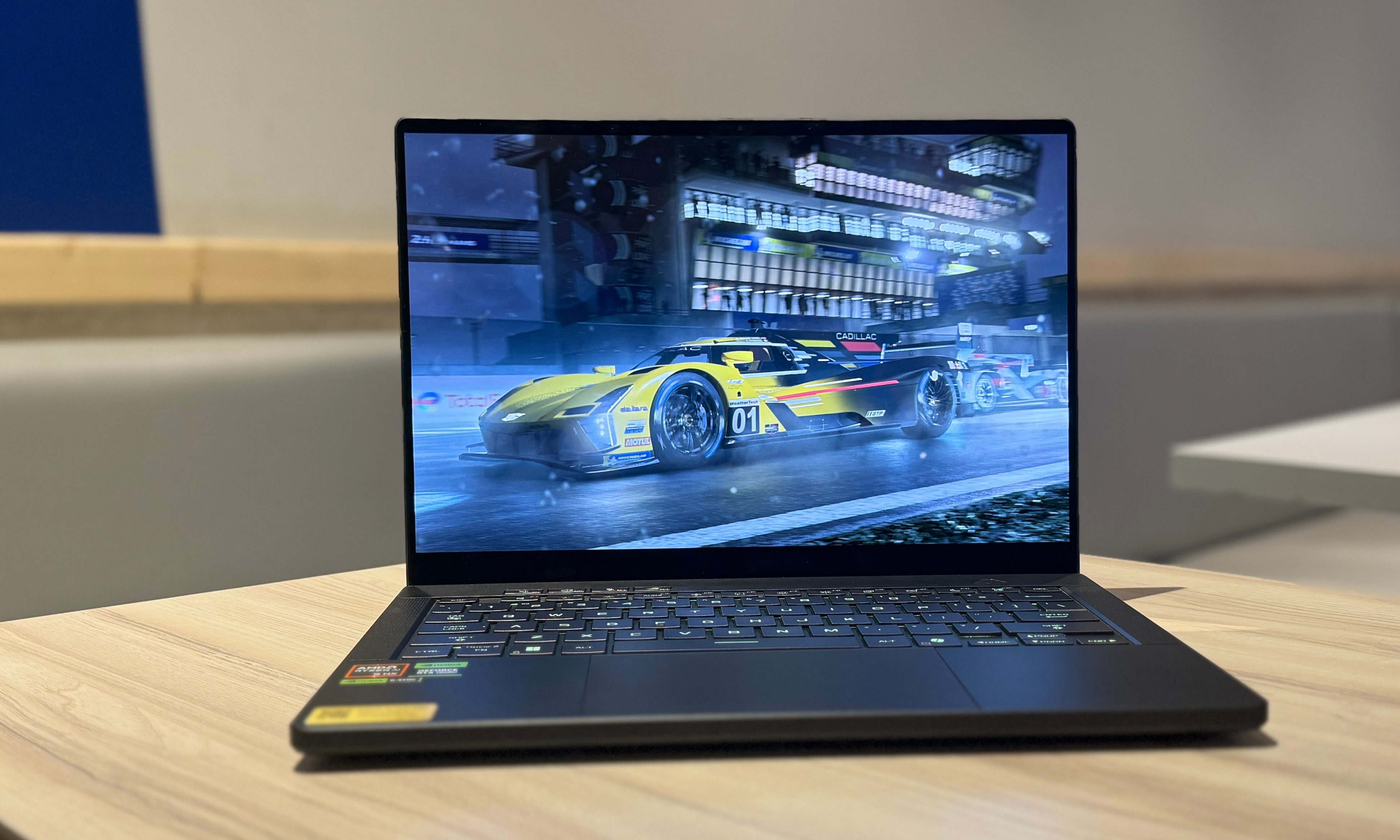 On the tabletop, there's an Asus ROG Zephyrus G14 laptop. The
