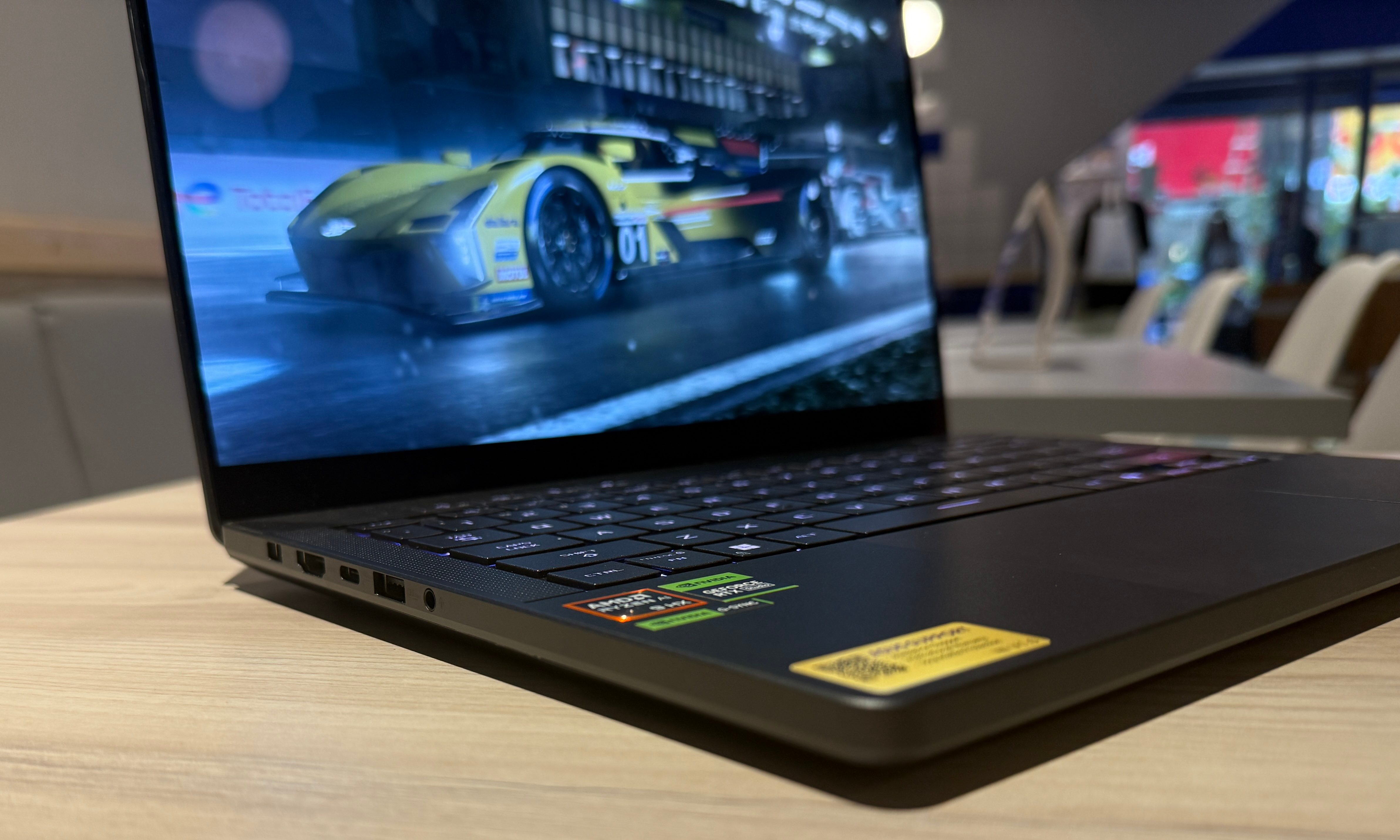 The Asus ROG Zephyrus G14 laptop is set on a table.