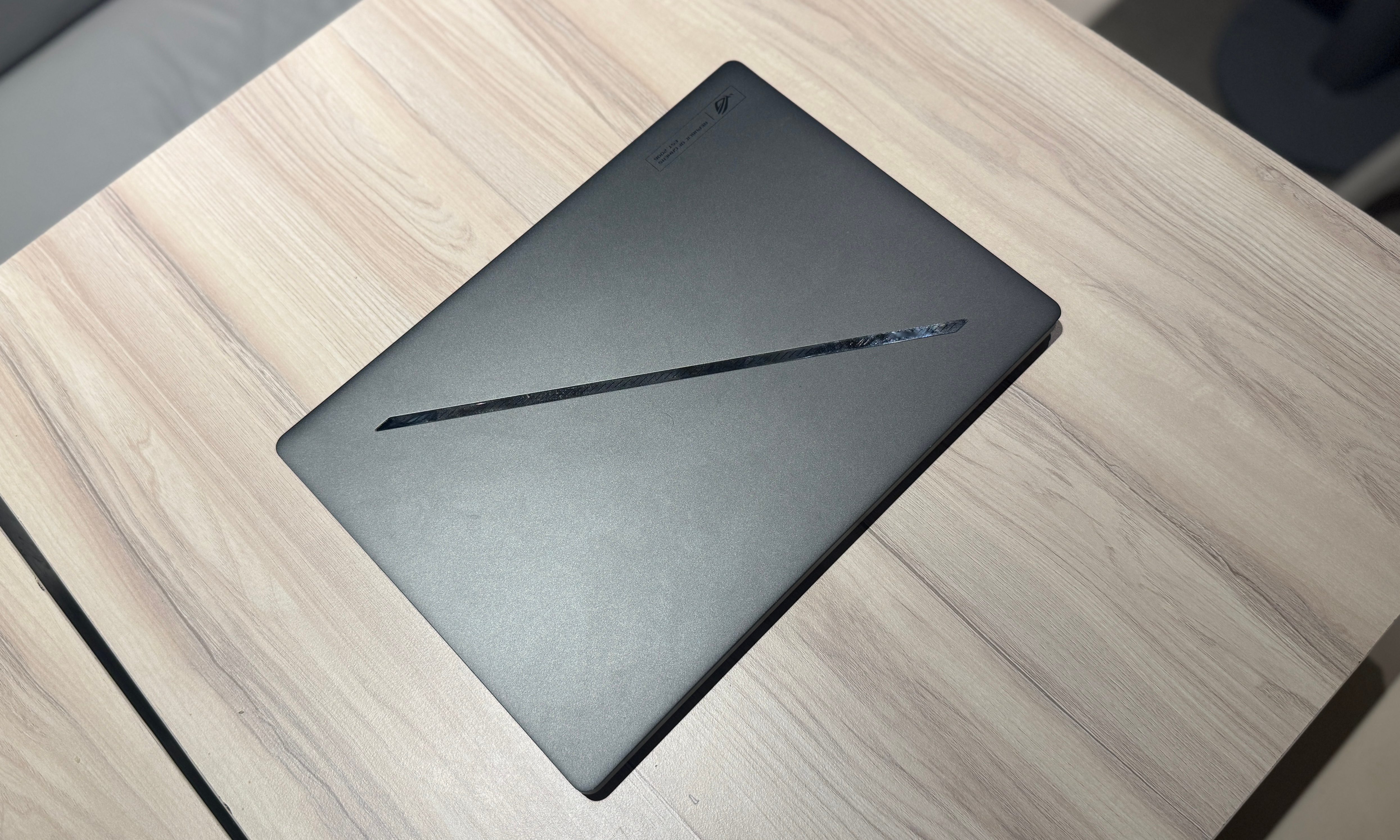 On the table sits an Asus ROG Zephyrus G14 laptop
