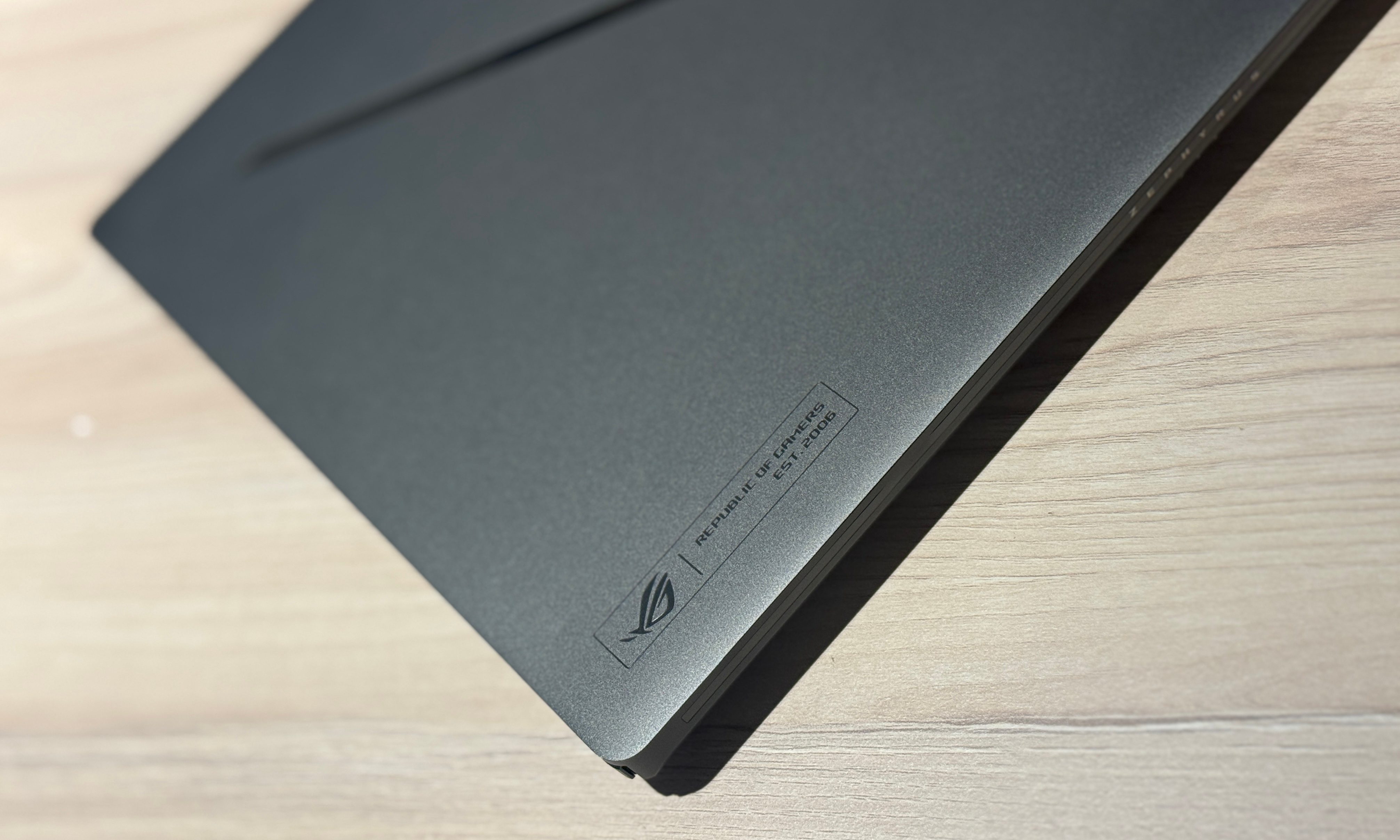 A table supports the Asus ROG Zephyrus G14 laptop