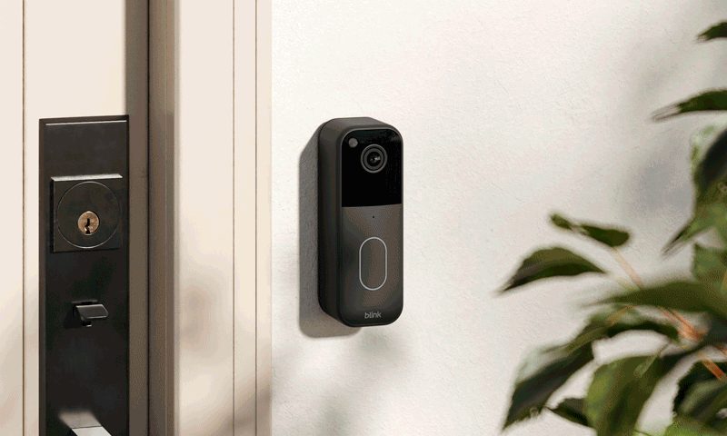 The 2023 model of the Blink Video Doorbell on a while wall next to a front door
