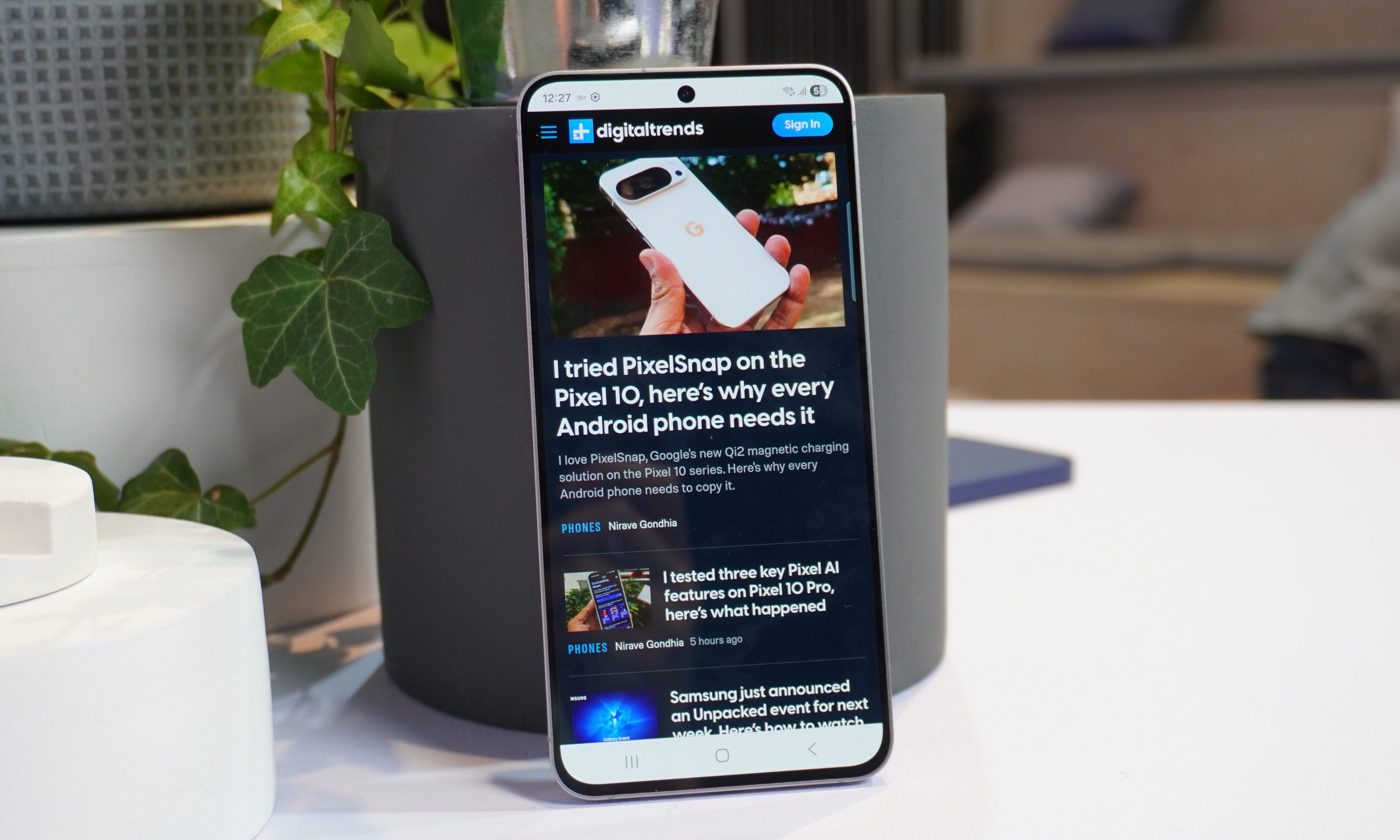 The Galaxy S25 FE propped up against a grey plant pot, with the screen facing the camera.