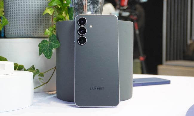 The Galaxy S25 FE propped up against a grey plant pot, with the rear of the phone facing the camera.