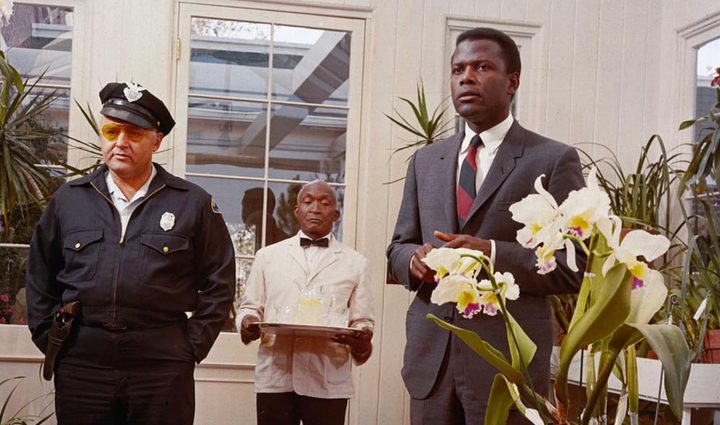 Two men stands next to each other and look.