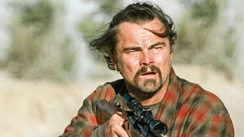 Leonardo DiCaprio holding a sniper rifle in One Battle After Another.