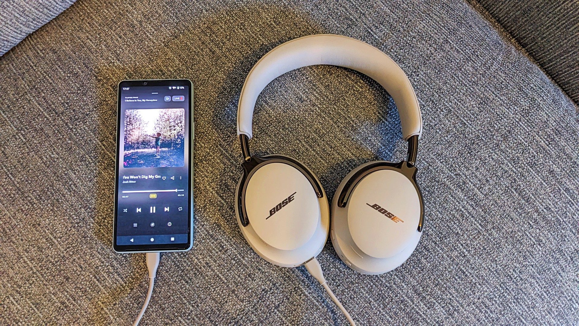 Bose QC Ultra Headphones (2nd Gen) next to a phone connected by a cable