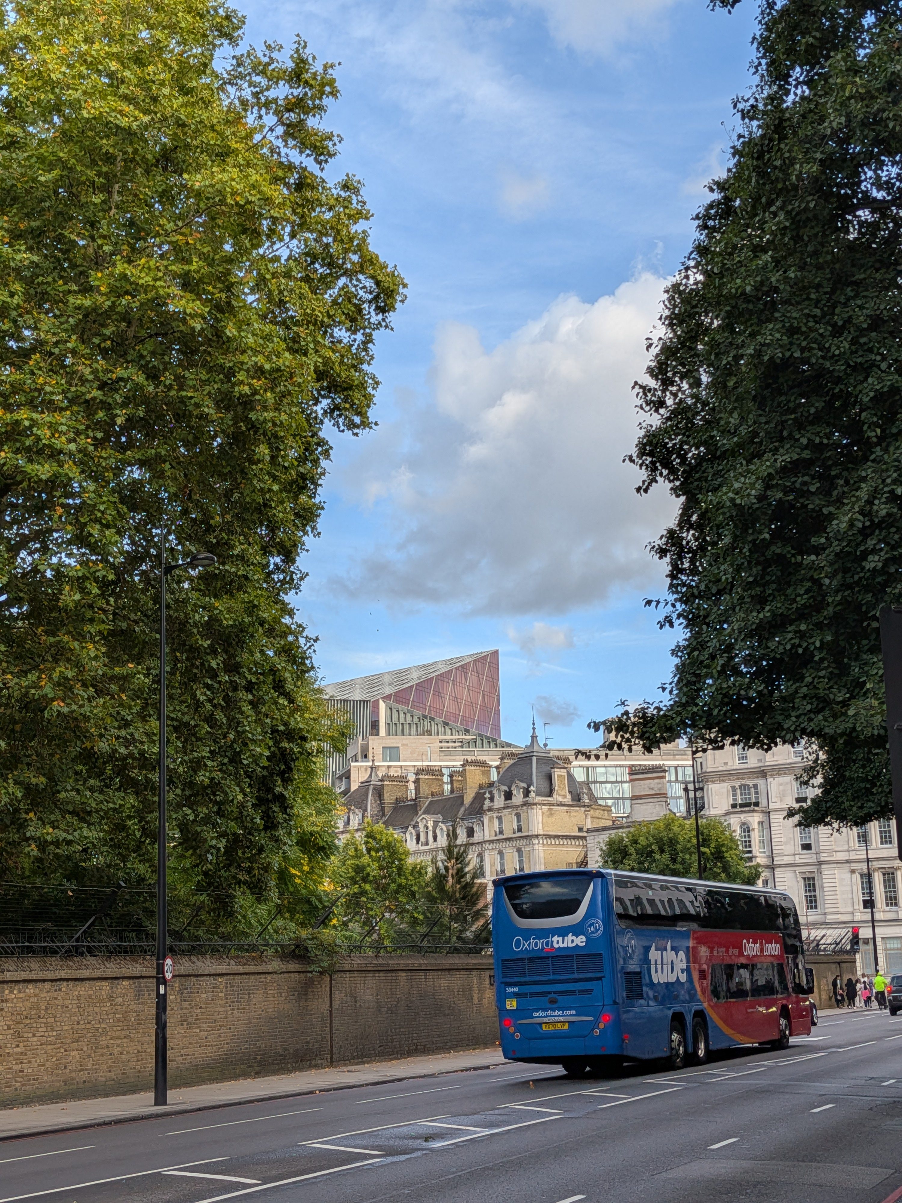 A pink-hued skyscraper in the distance, poking out of the skyline in London