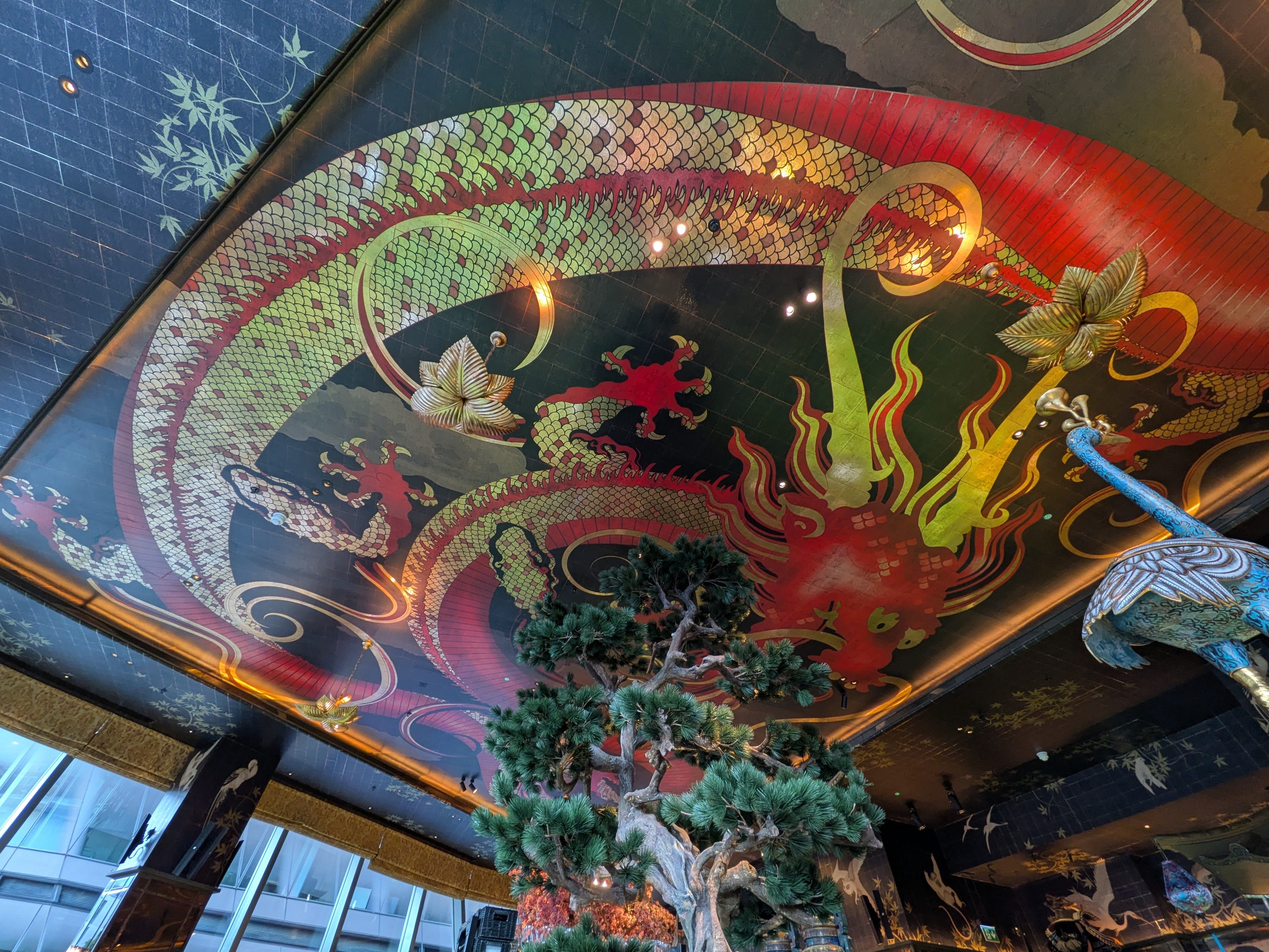 An ornate and colorful painted ceiling in an Asian restaurant