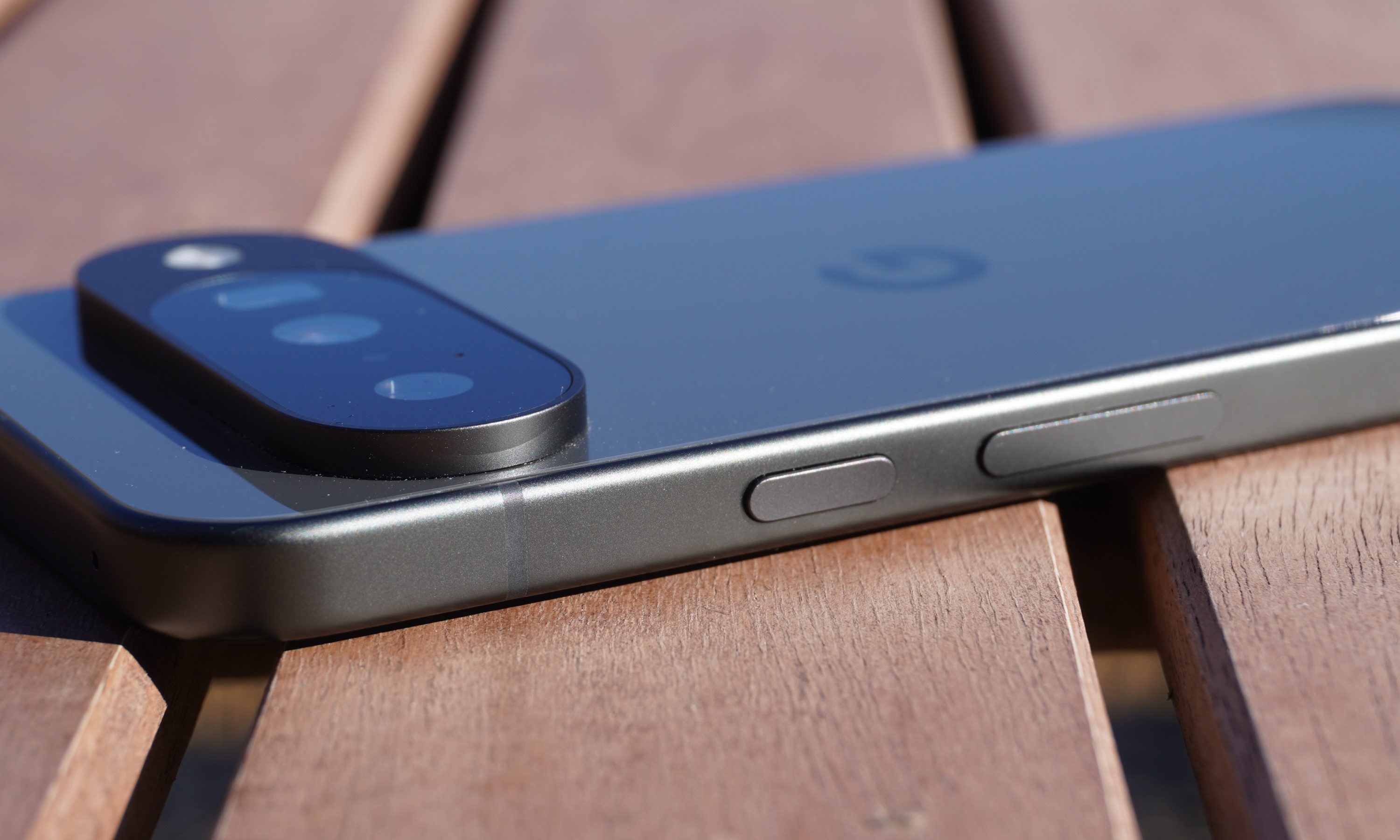 The power and volume buttons on the side of the Pixel 10 lying on a table