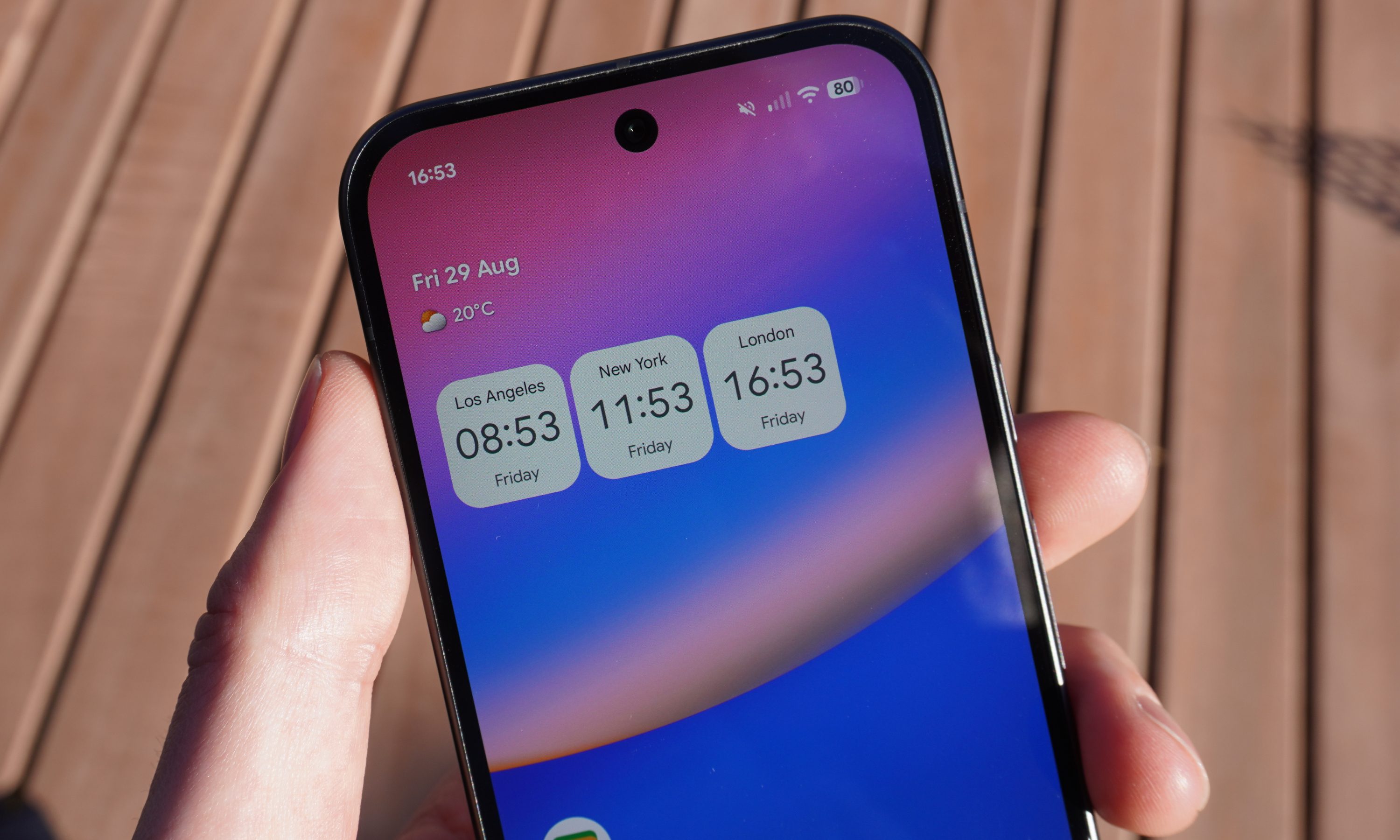 Top half of the Pixel 10 display, showing home screen with a world clock widget