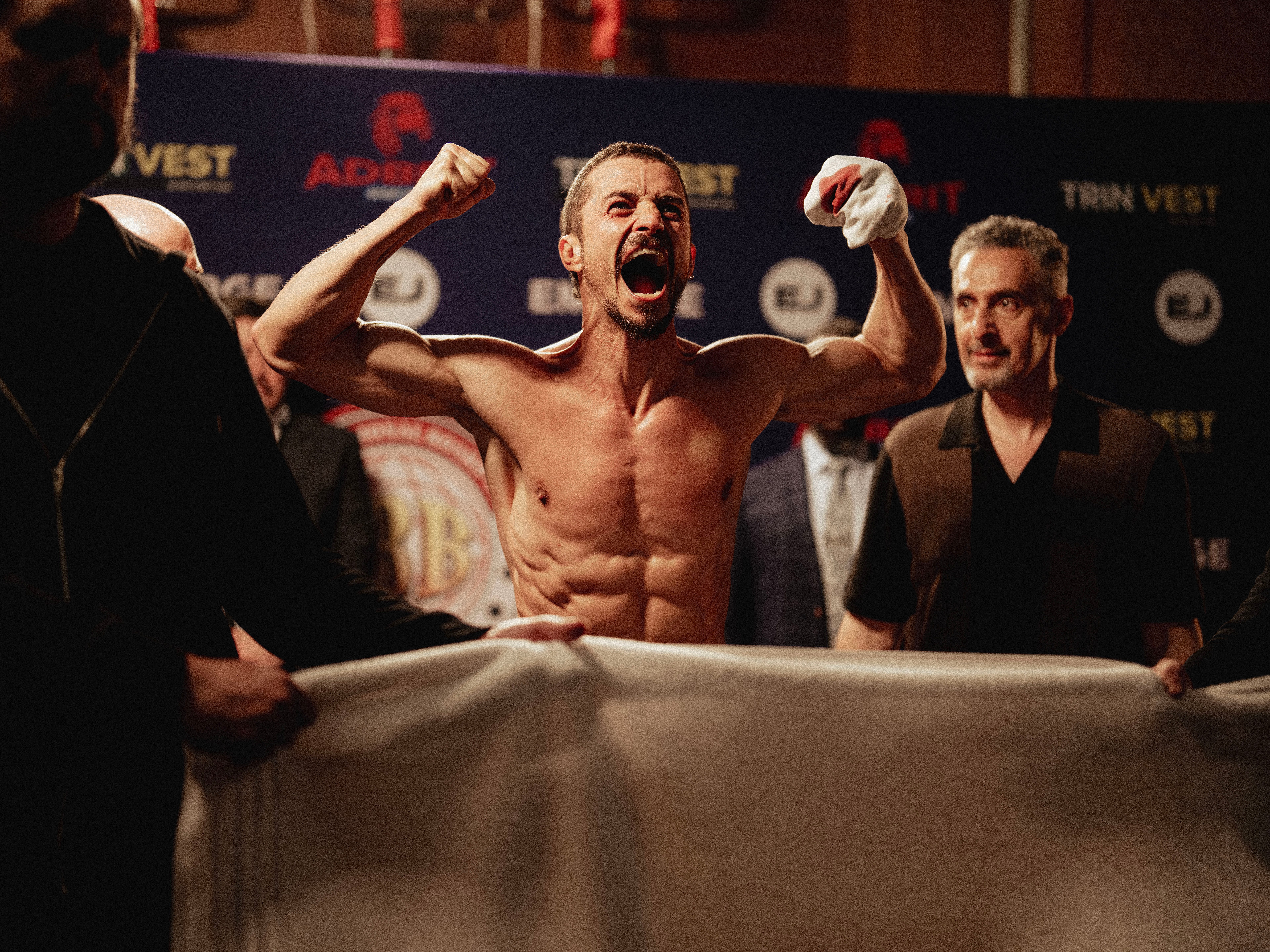 A boxer flexes and smiles.