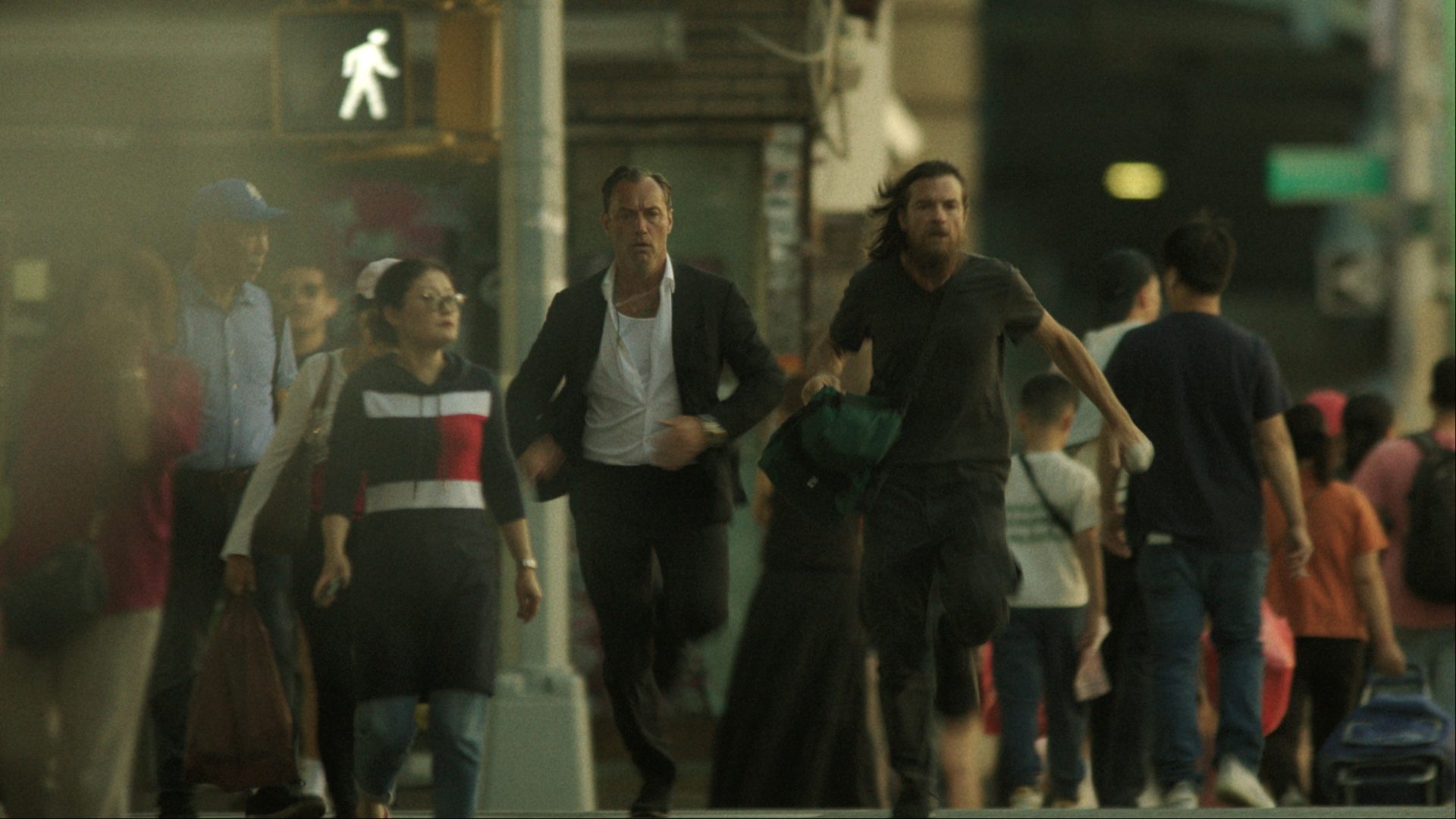 Two men sprint in the streets.