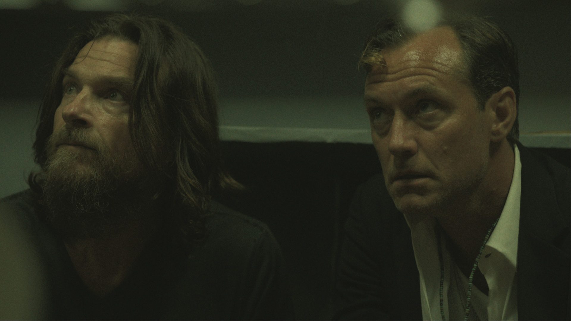 Jason Bateman and Jude Law look up and stare.