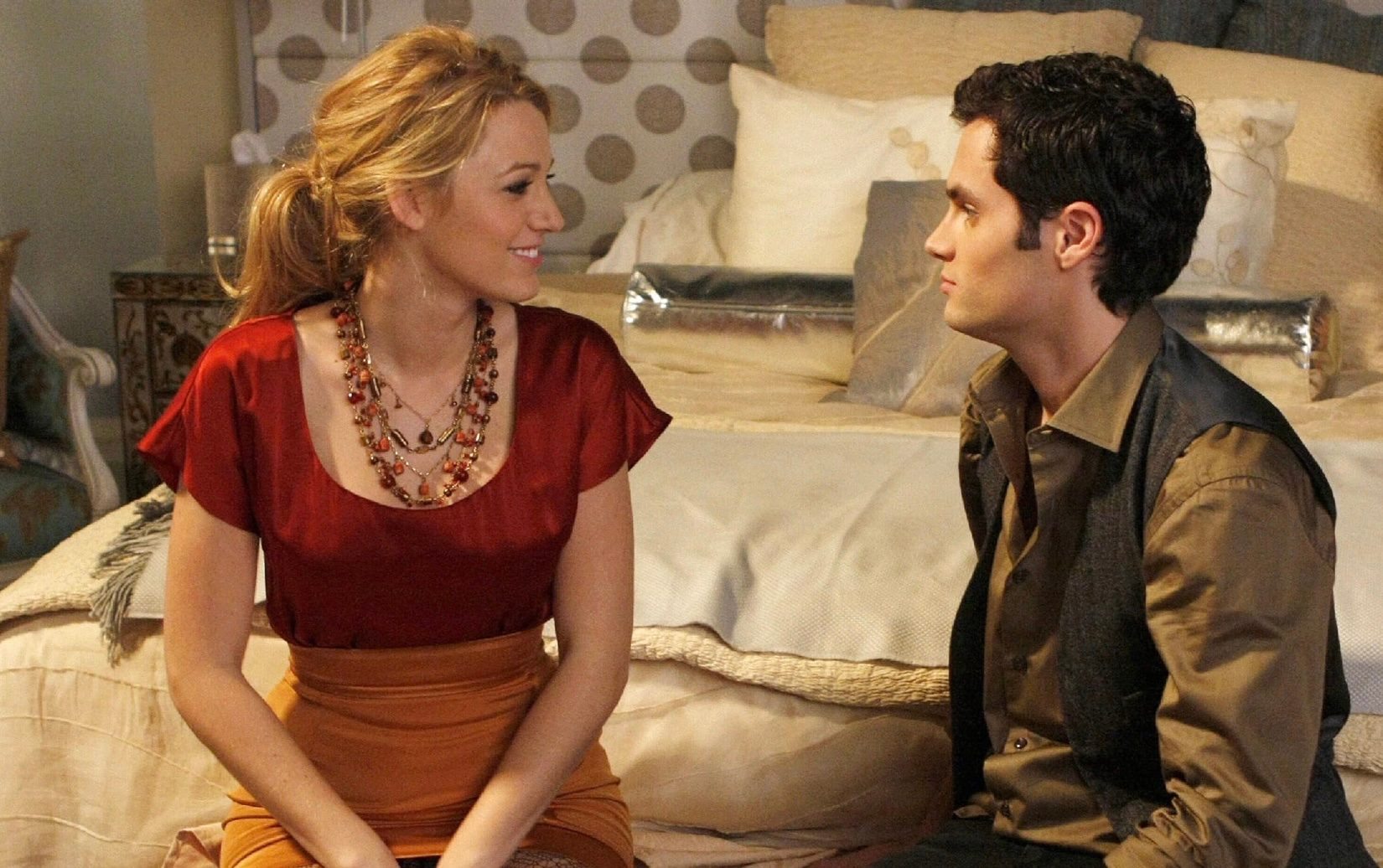 A woman sits on a bed with a man.