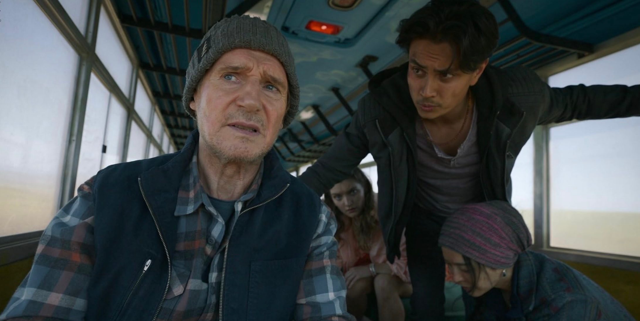 Liam Neeson drives a bus full of people.