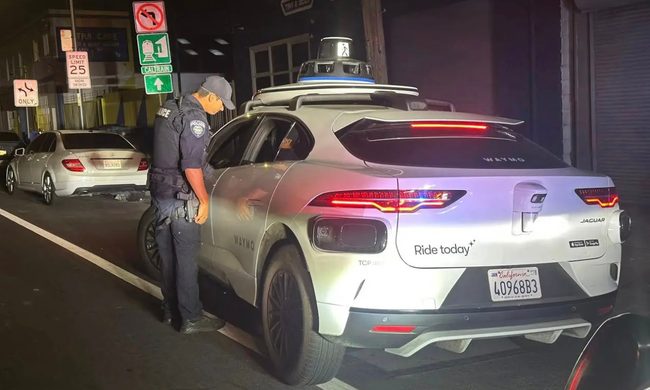 A police officer investigating an empty Waymo car.