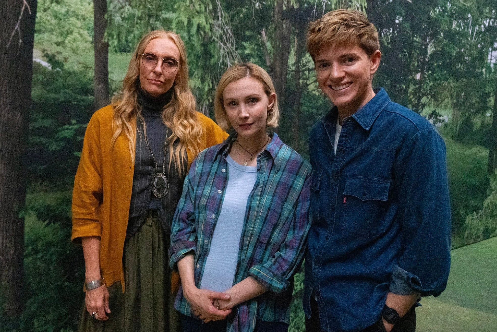 Three people stand together in a line.