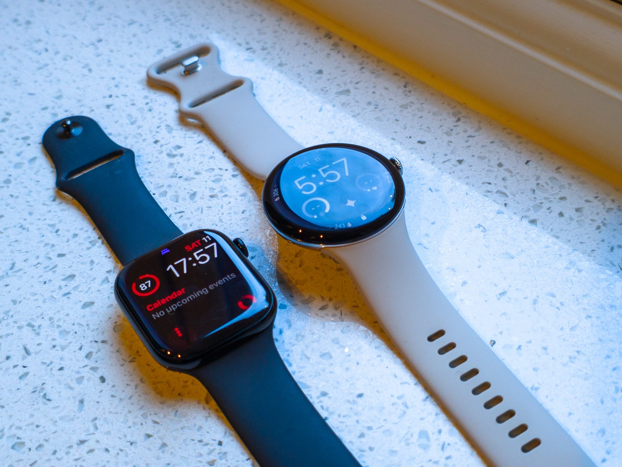 Apple Watch 11 black next to Google Pixel Watch 4