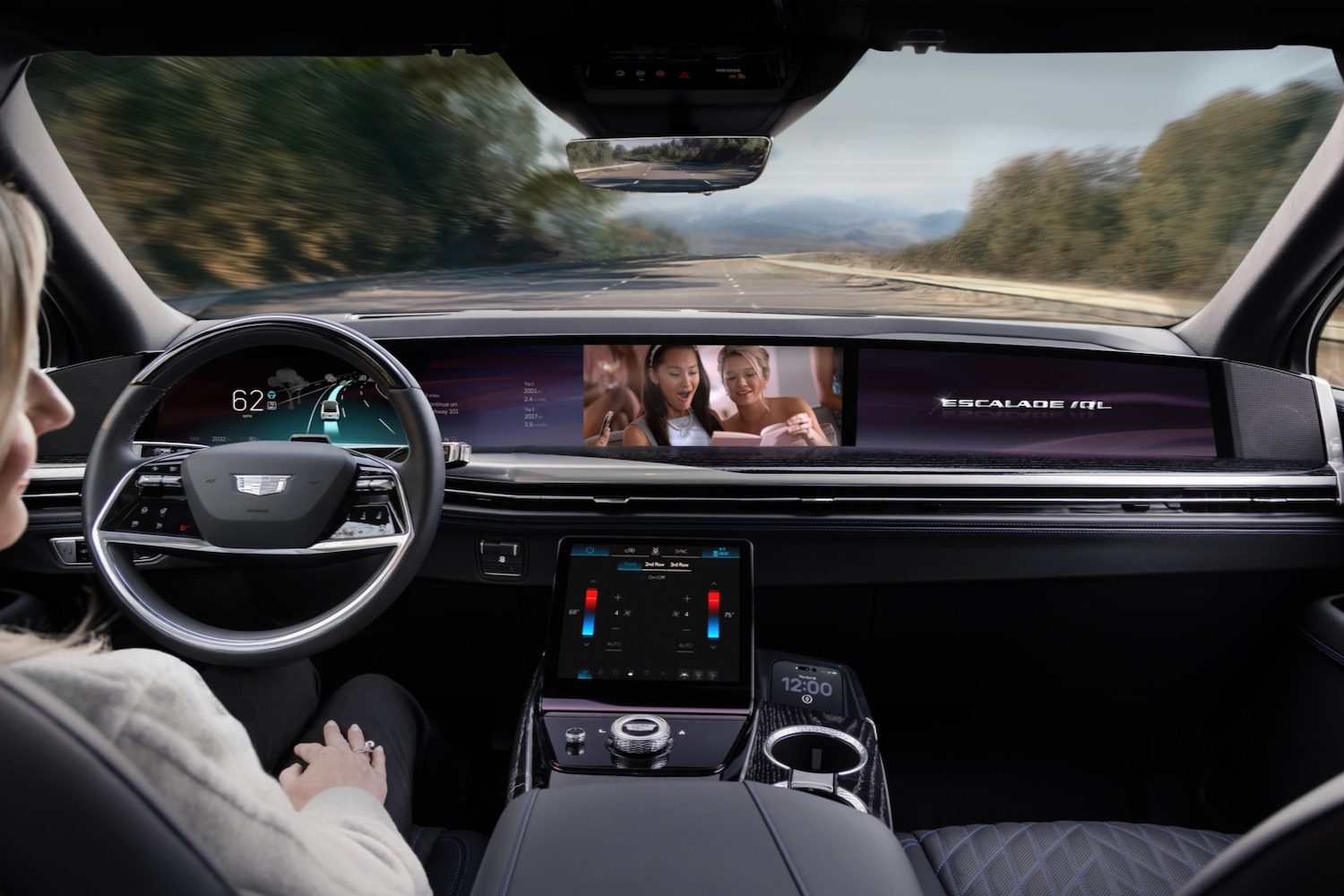 A woman watches a video on the dashboard of a Cadillac Escalade IQ.