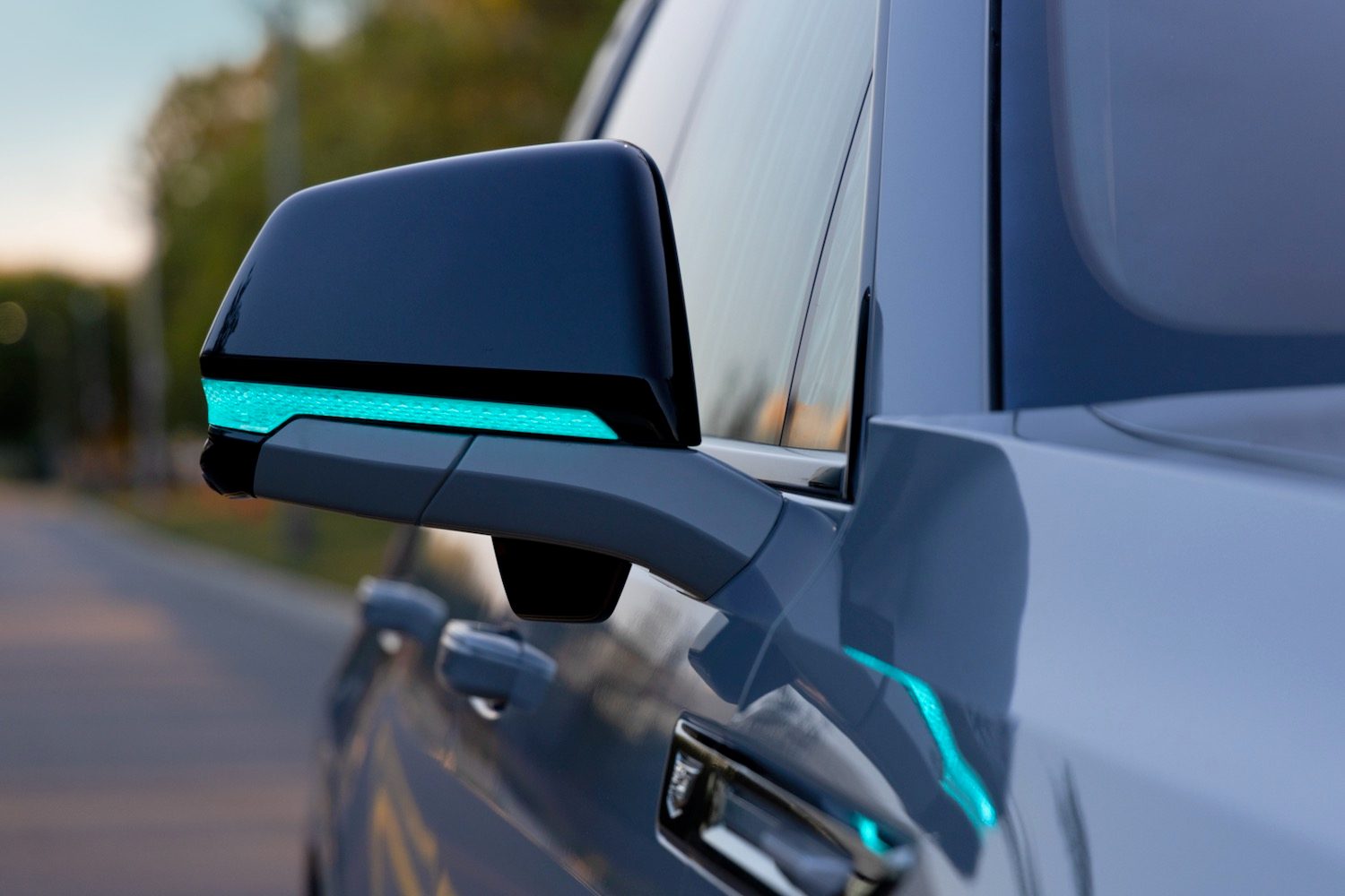 Turquoise light on the exterior mirror of a Cadillac Escalade IQ.