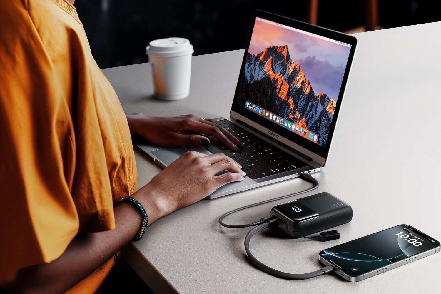 The INIU Cougar P63 Power Bank 100W 25000mAh with a laptop and phone.