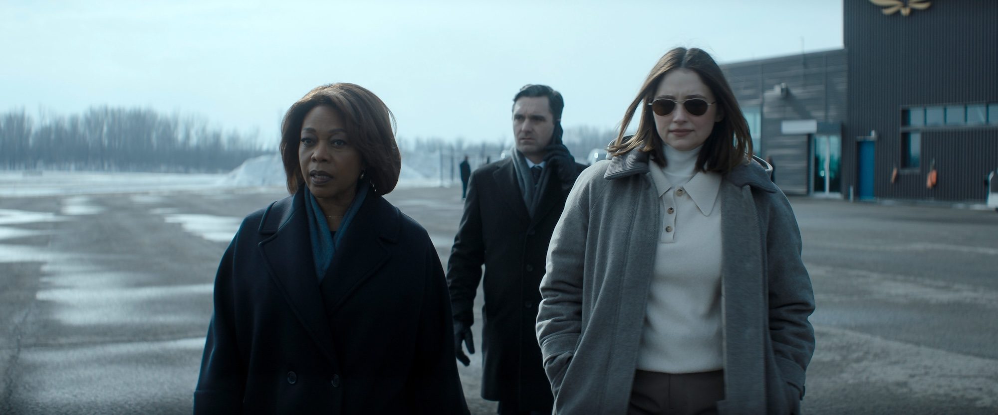 Two women walk on a tarmac.