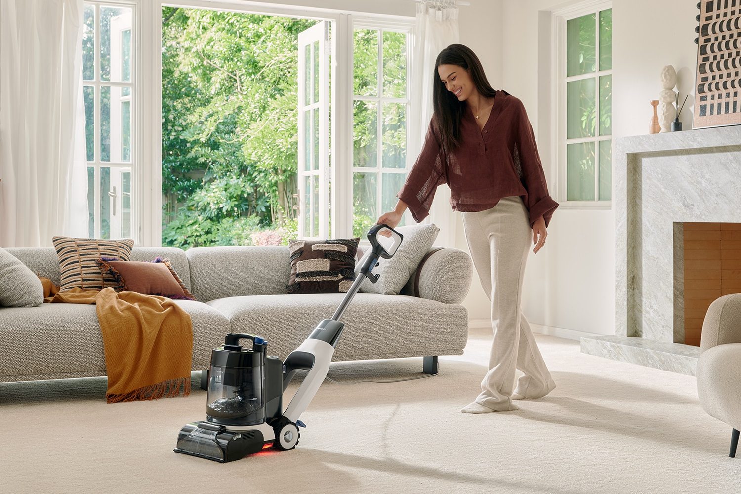 A woman using the Tineco Carpet One Cruiser smart carpet cleaner.