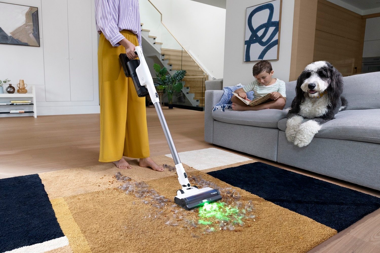 A person using the Tineco Pure One Station 5 smart cordless vacuum.