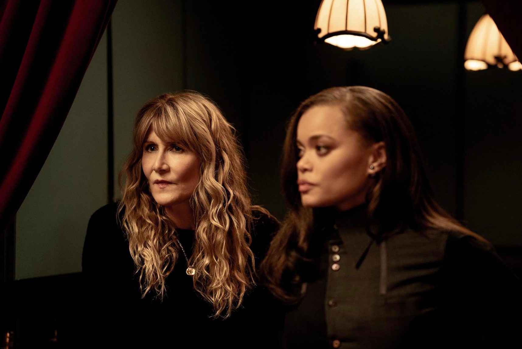 Two women stand next to each other and stare.
