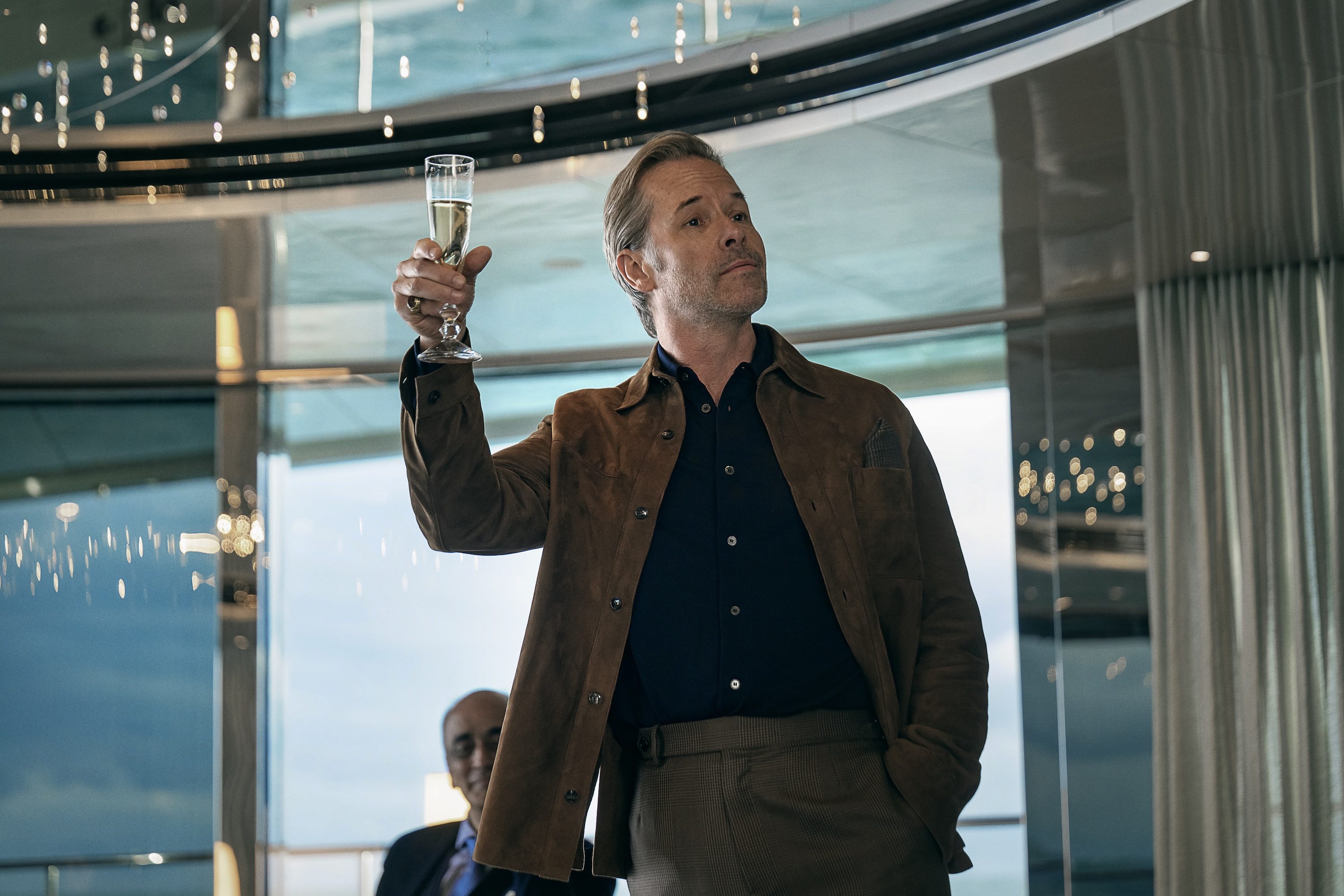 A man holds up a glass of champagne.