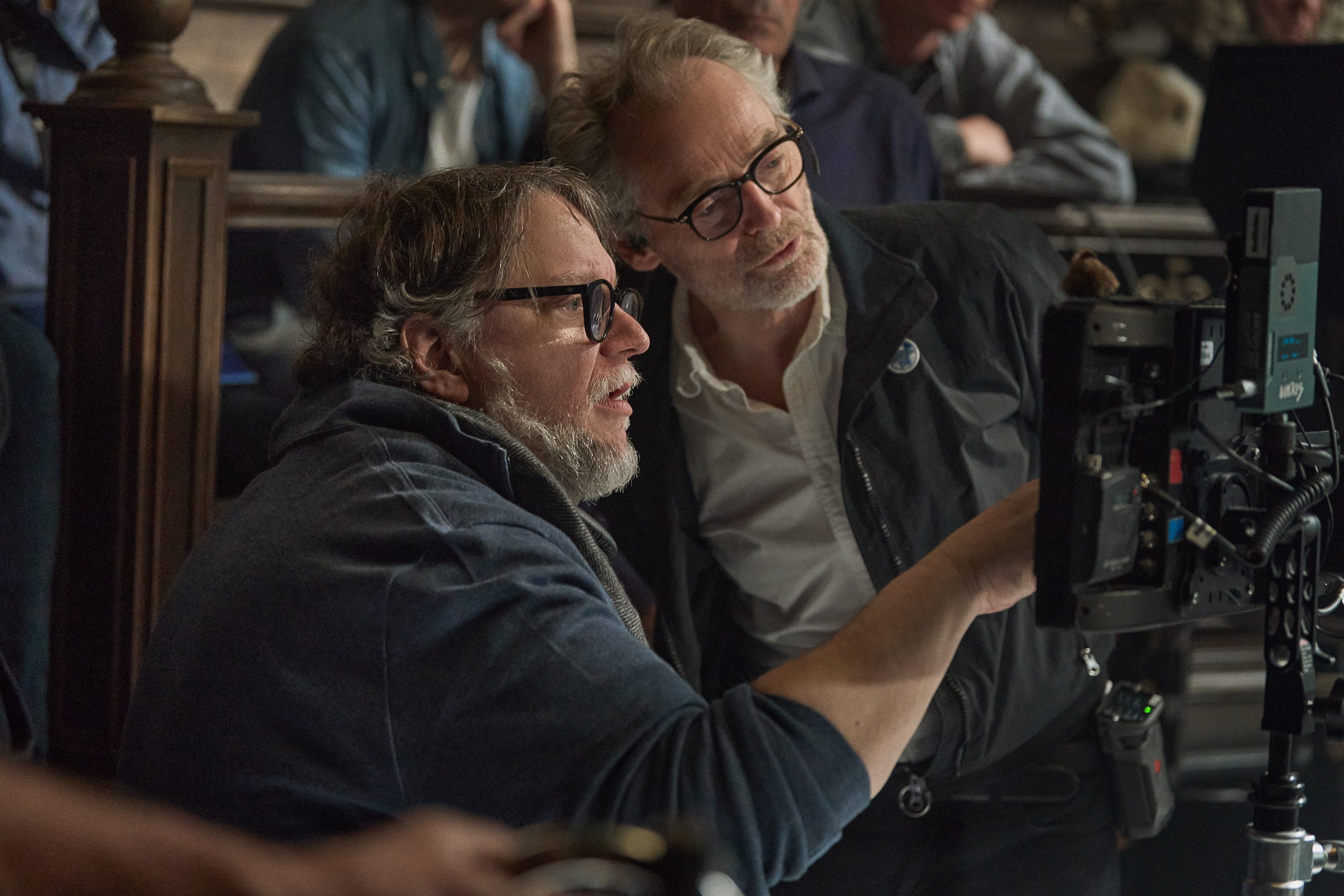 A director and cineamatographer stand behind the camera in Frankenstein.