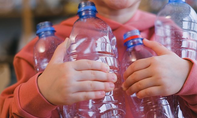 Kid holding plastic bottles