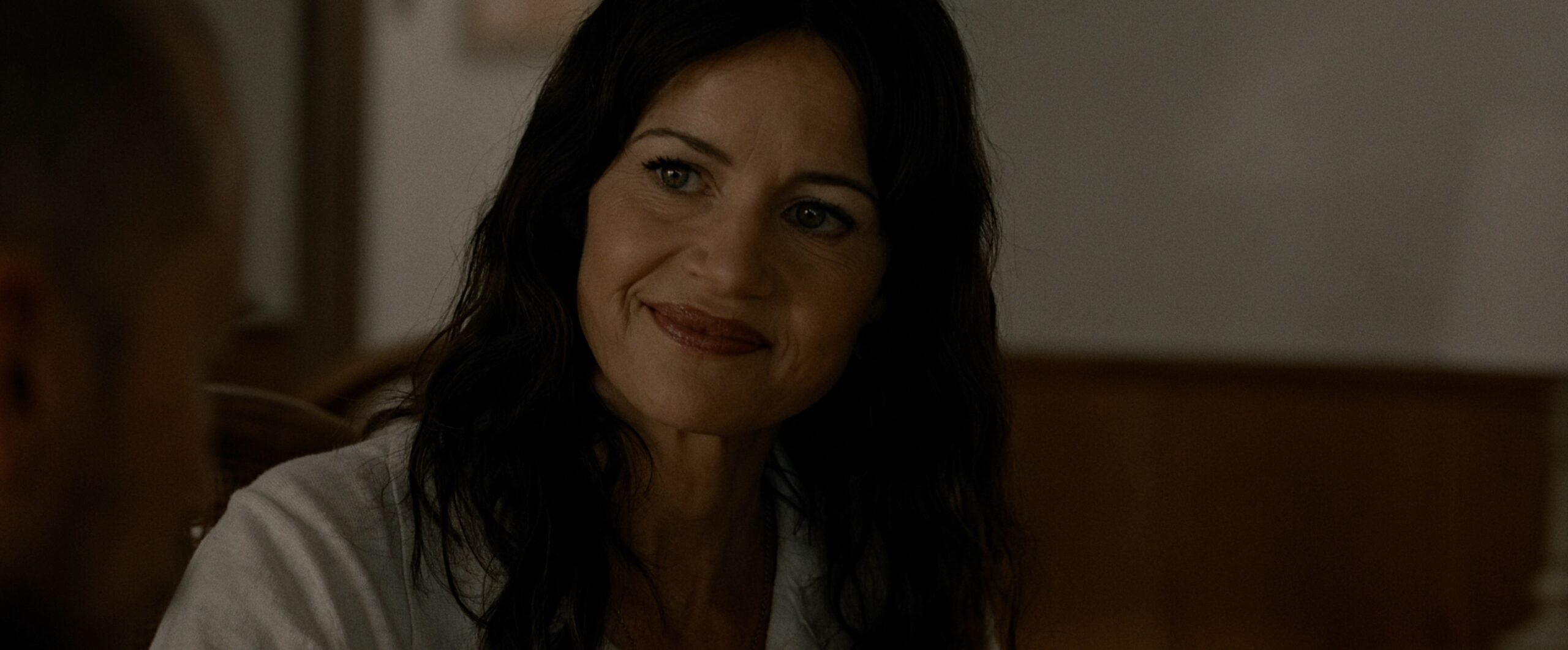 Carla Gugino smiling in the horror film, Lockbox