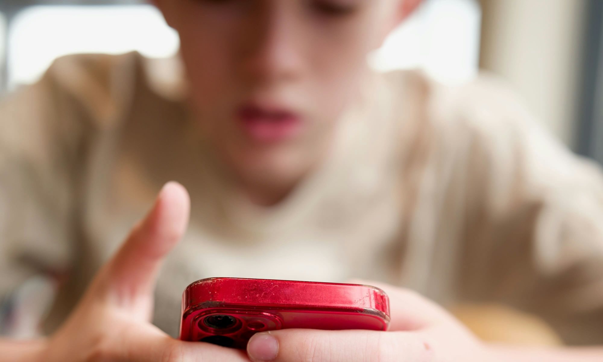 Child using a red iPhone